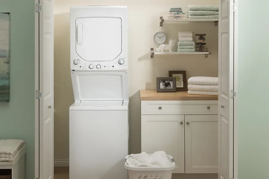 GE GUD24ESSMWW white stacked electric laundry center with top-load washer, designed for efficient use of vertical space in tight closets.